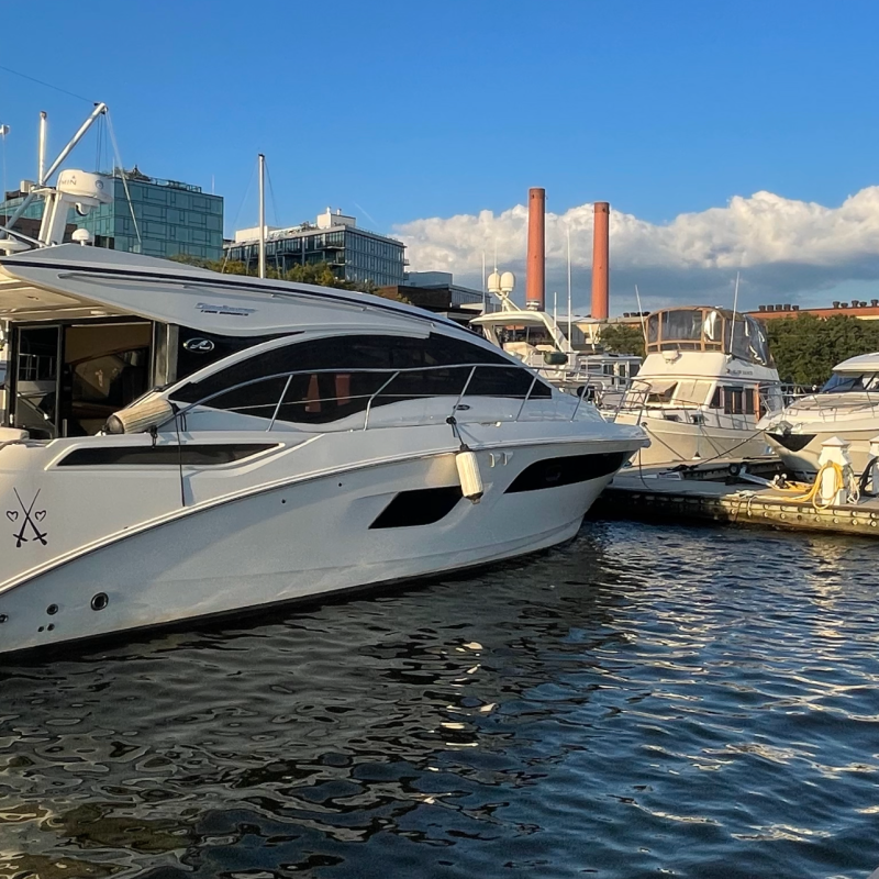 Several yachts docked at a marina under a clear blue sky.